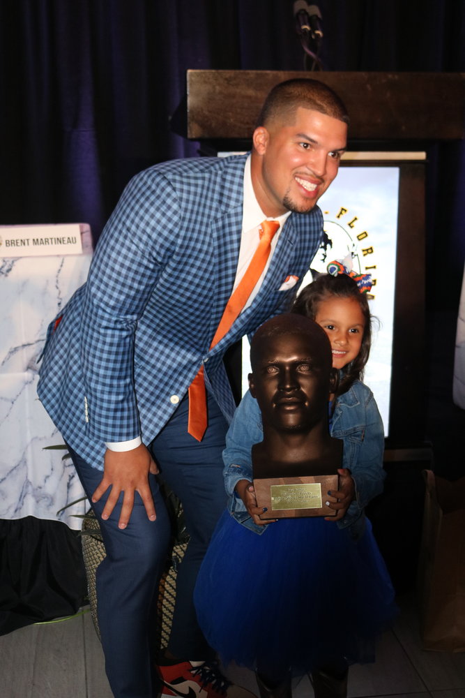Trey Burton poses with his daughter, while she holds his Hall of Fame bust.